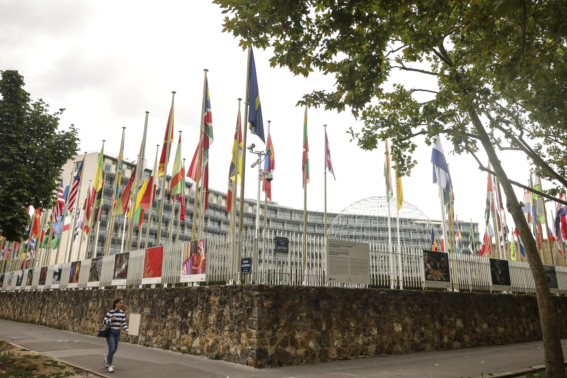 A woman walks by the UNESCO headquarters Tuesday, July 22, 2025 in Paris. (AP Photo/Thomas Padilla)