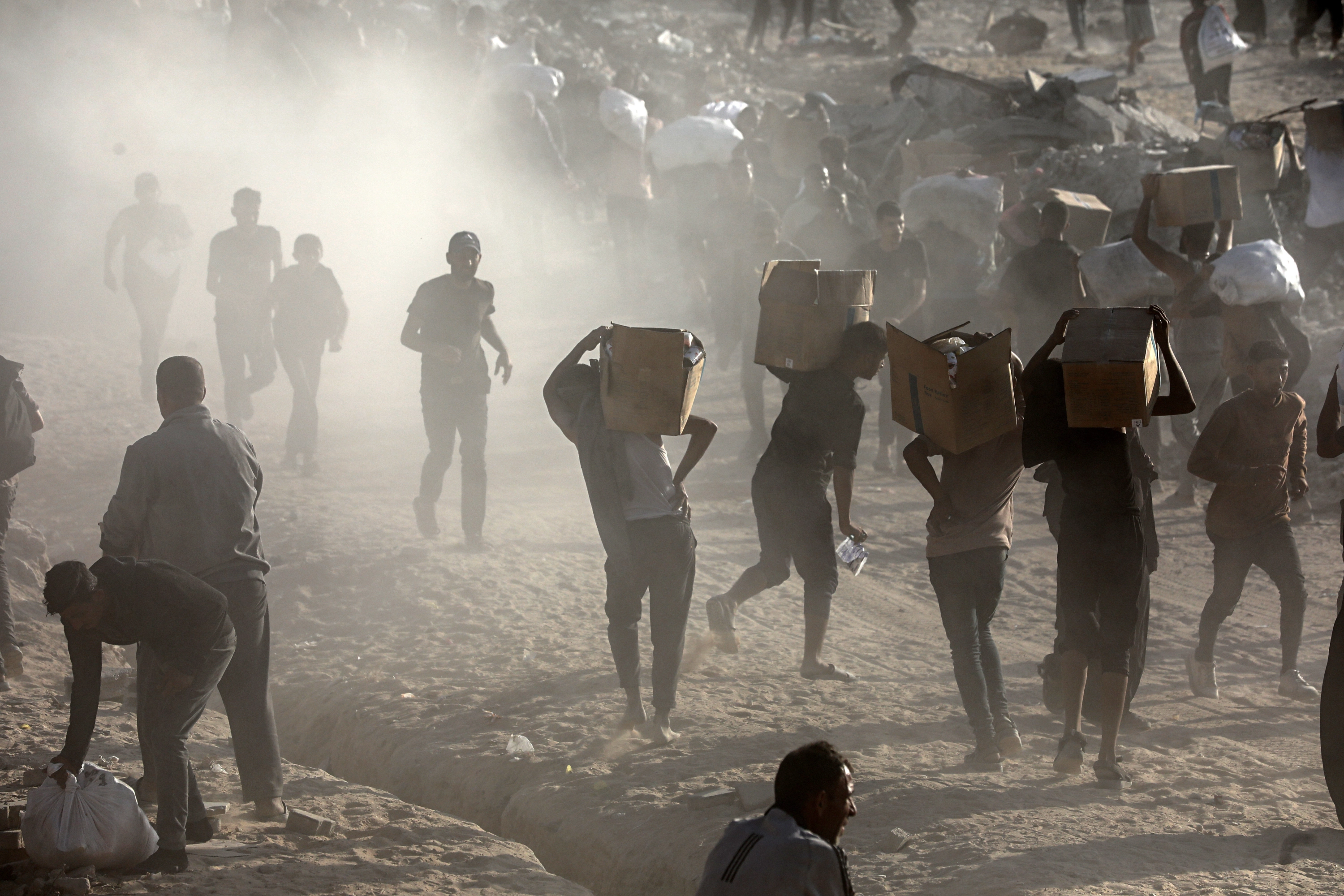Palestinos recogen paquetes con ayuda humanitaria en Gaza.
